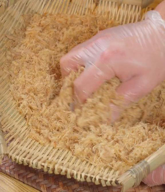 Rubbing and tearing the pork floss against the bamboo sieve