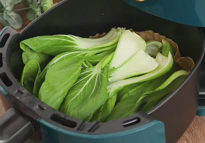 place bok choy in an air fryer basket lined with parchment paper or foil