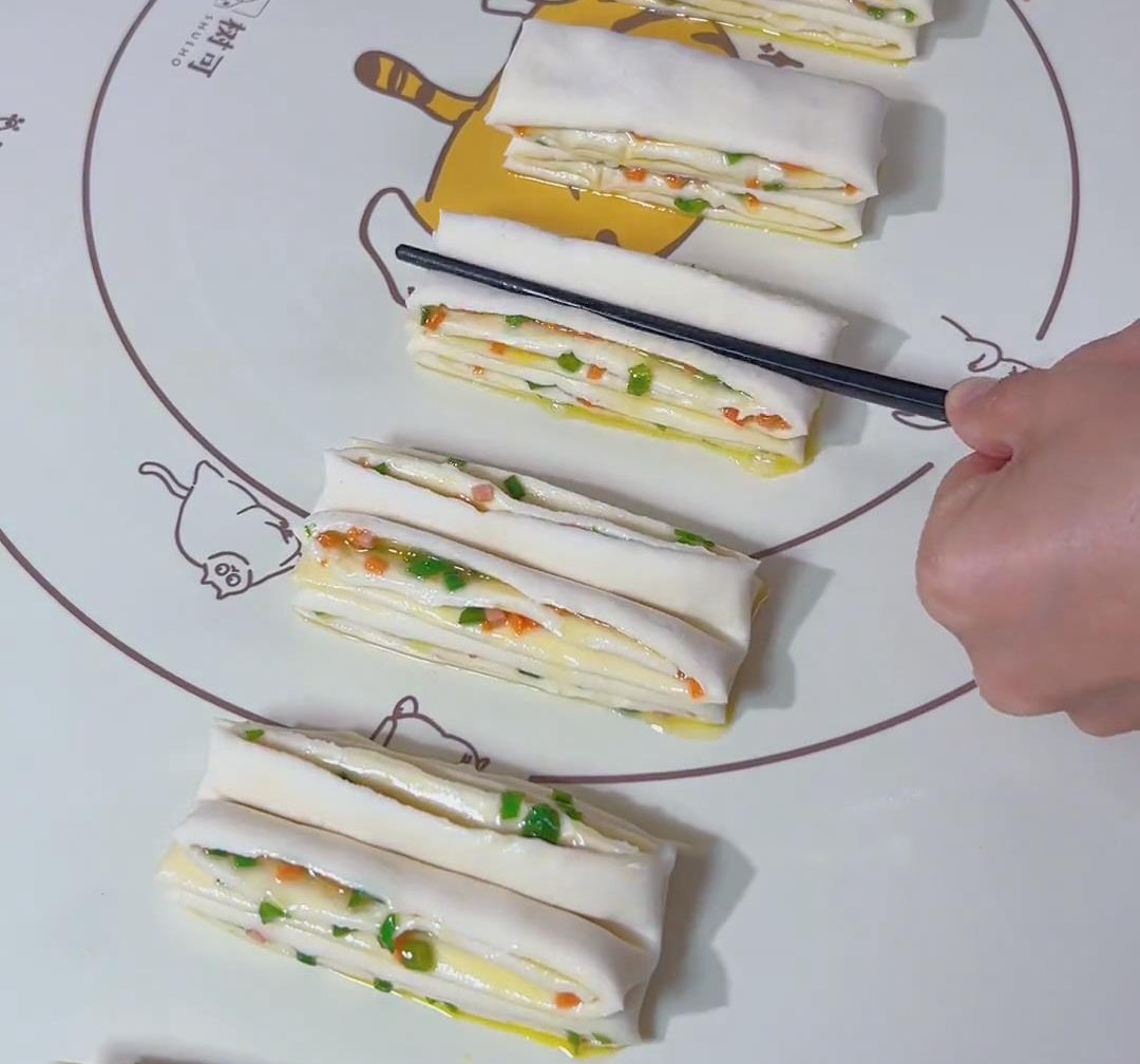 In the middle of the stacked strips, place a chopstick in the middle and press it