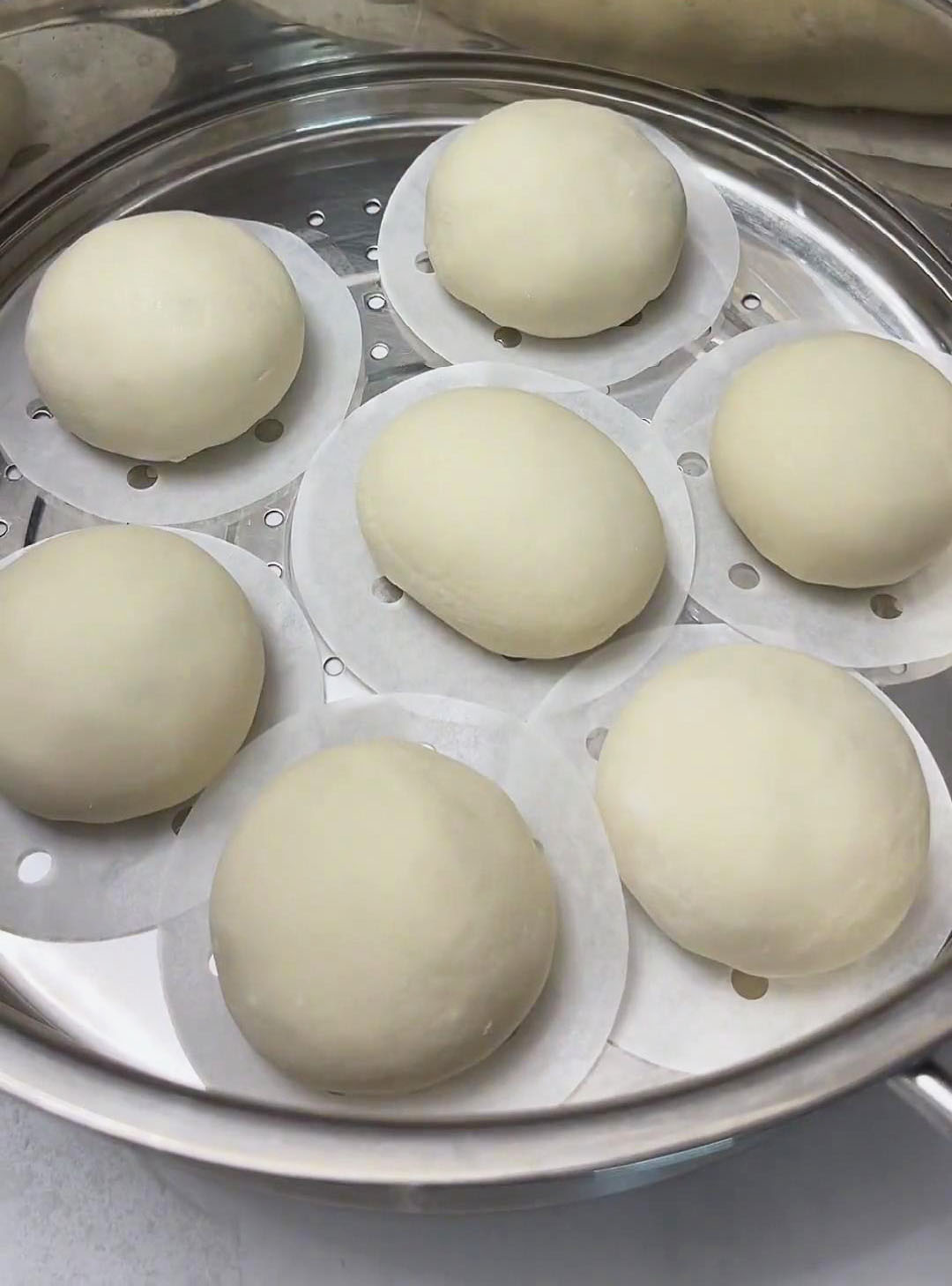 Place the buns in the steamer basket with parchment paper