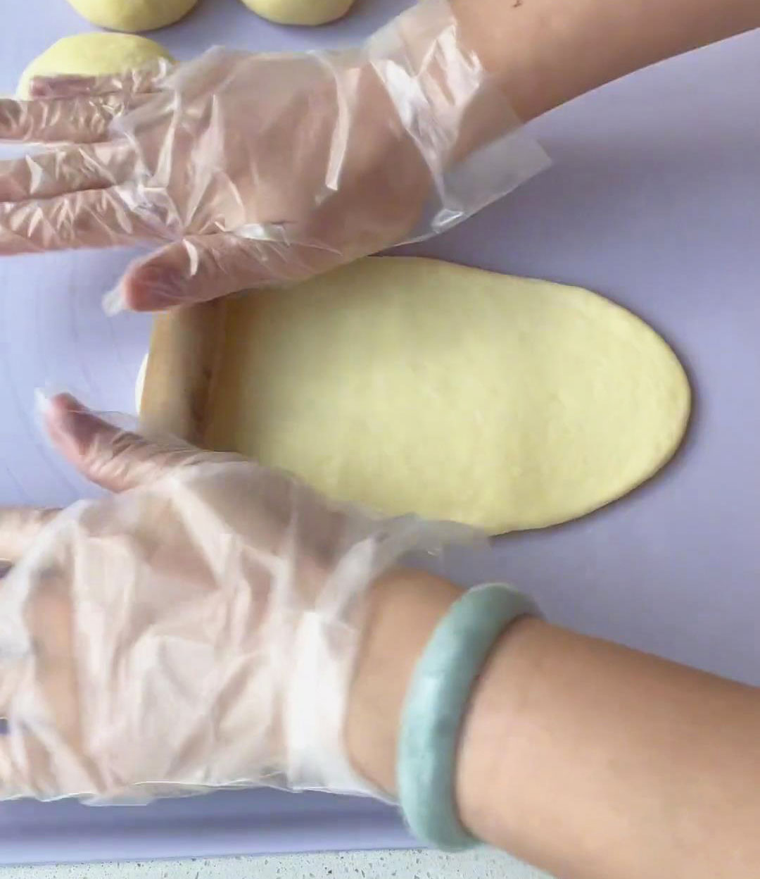 flatten each piece using a rolling pin to make a flat, oblong shaped dough wrapper