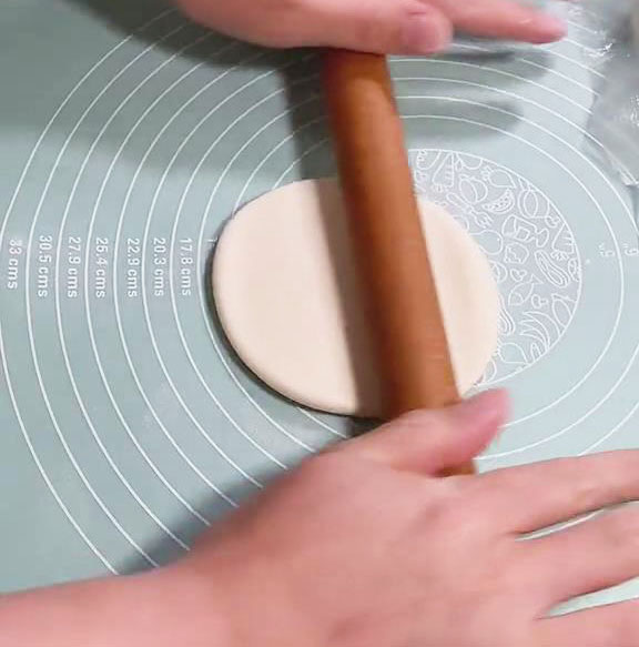 take the balls of dough and roll them into flat circular dough wrappers using a rolling pin