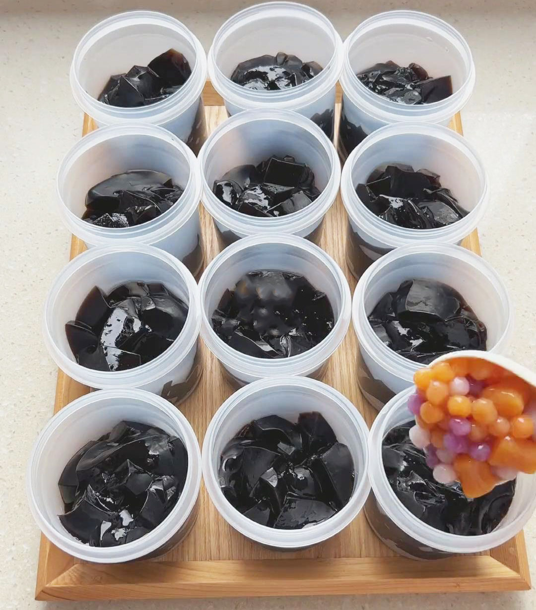 Assemble your dessert bowl by adding grass jelly, taro balls