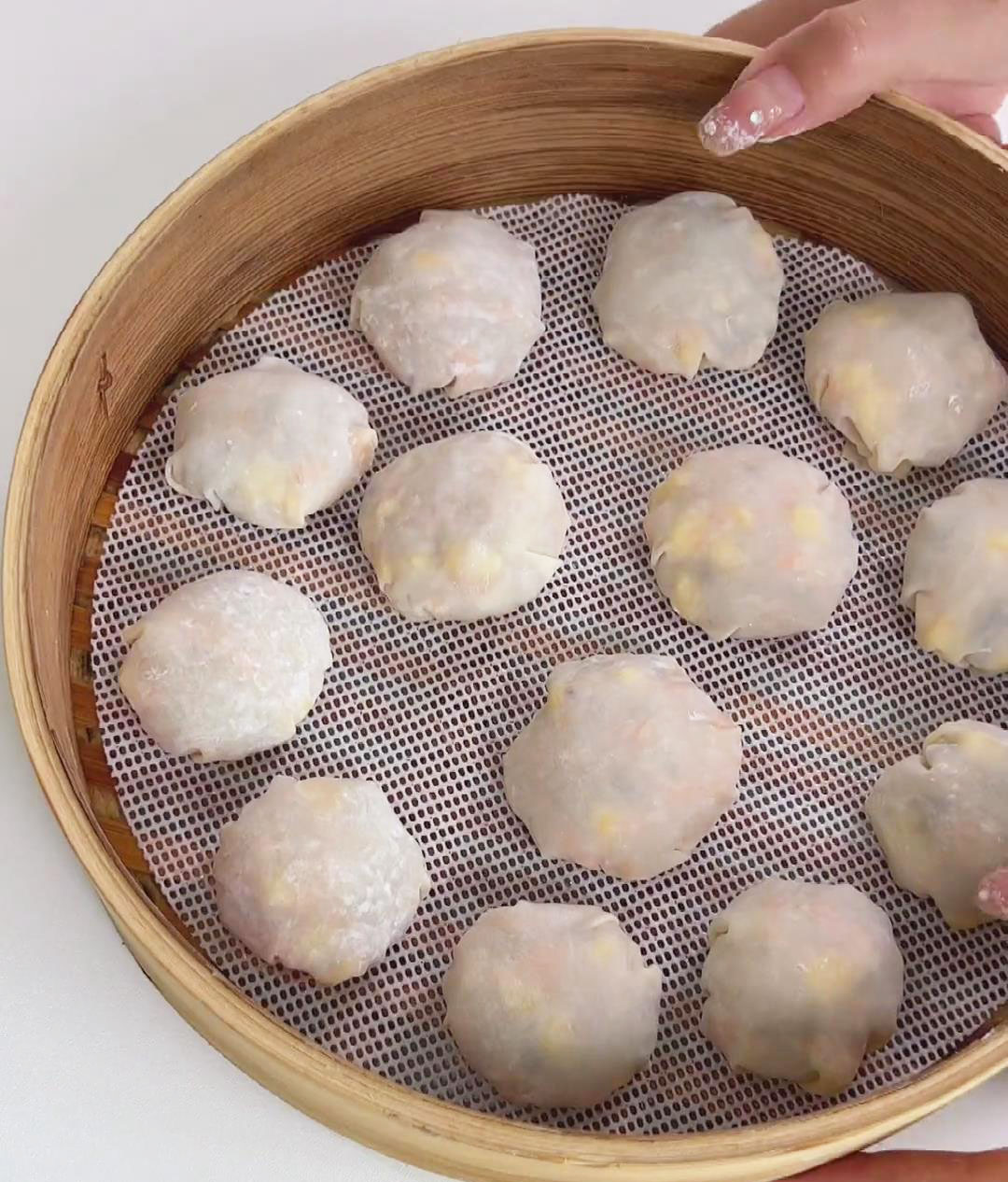 Line the steamer basket with parchment paper and place the wontons