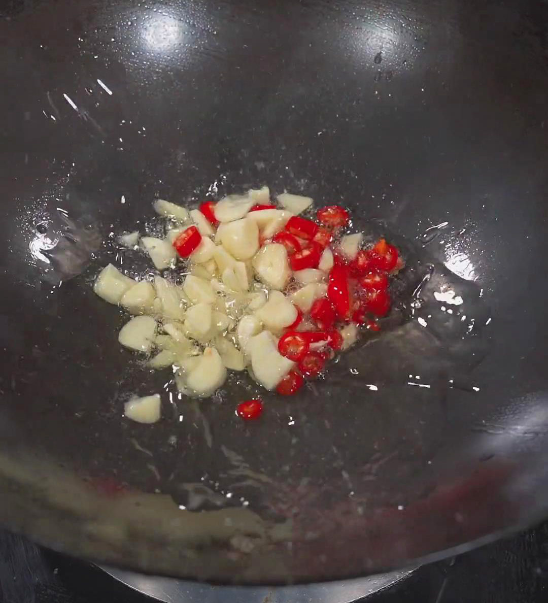 stir fry chopped garlic and Thai chili pepper