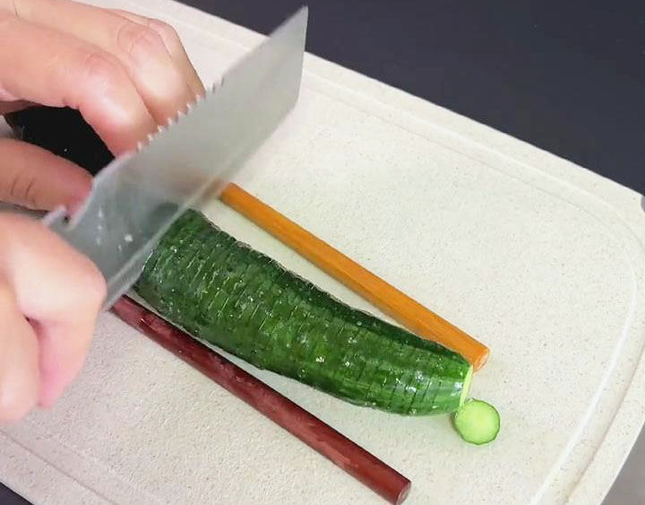 cut the cucumbers by placing chopsticks on each side and cutting it up to the chopsticks