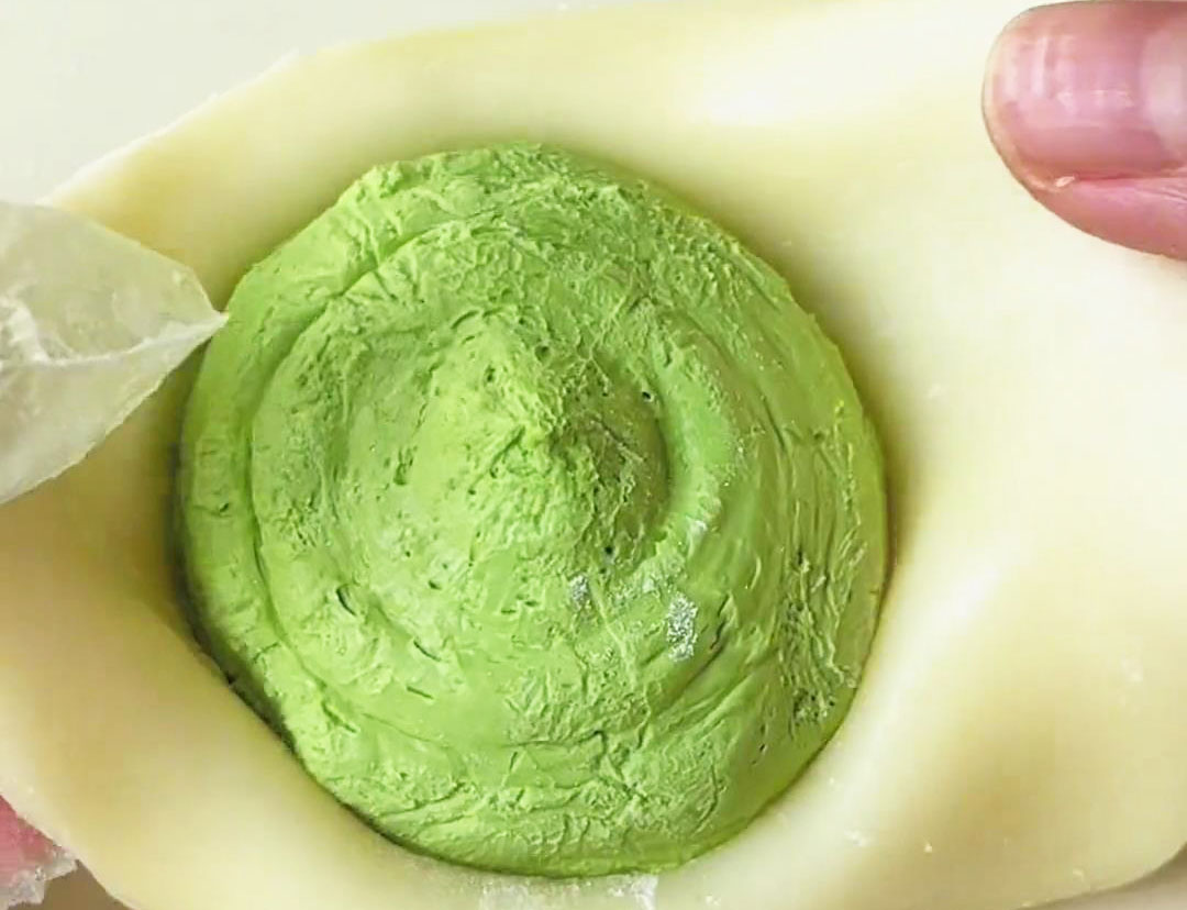 Place a portion of the frozen matcha filling in the center of each mochi disc