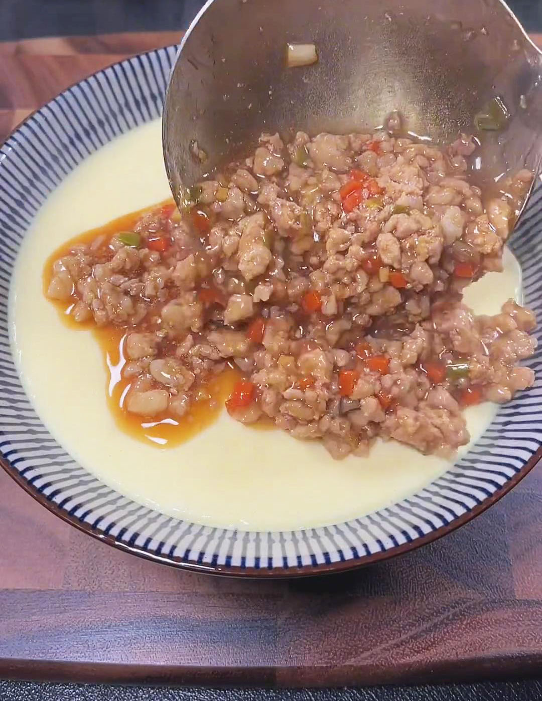 Pour the cooked minced pork mixture over the steamed tofu and eggs