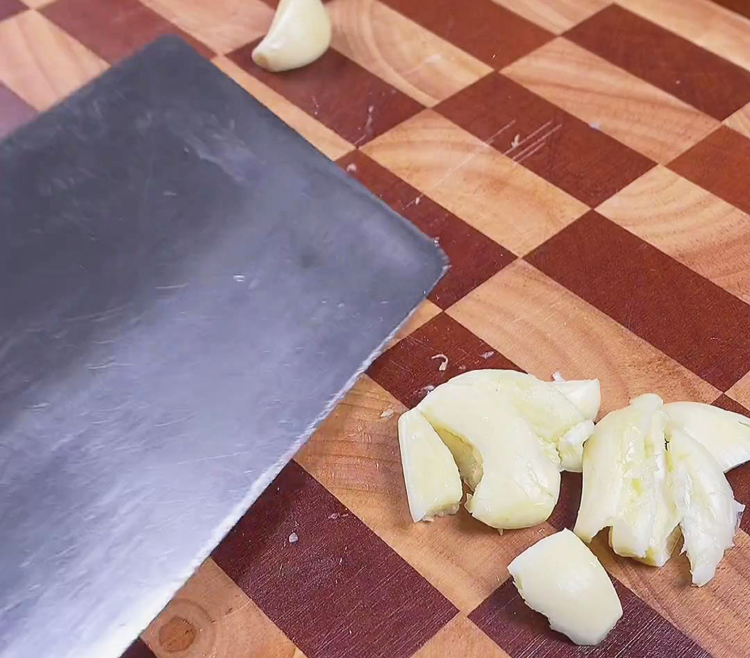 Remove the garlic skins and crush them with the knife