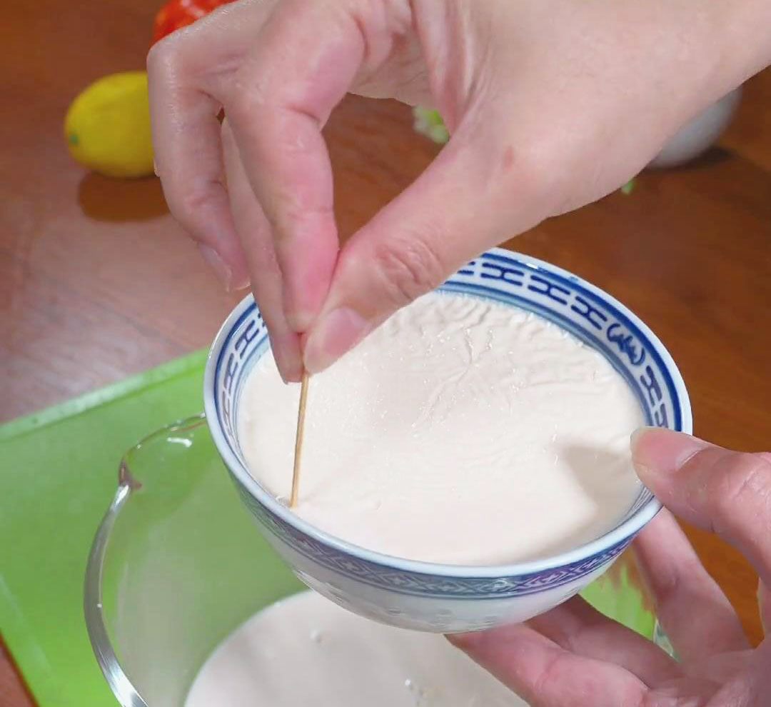 Using a toothpick, gently tease the edge of the milk skin