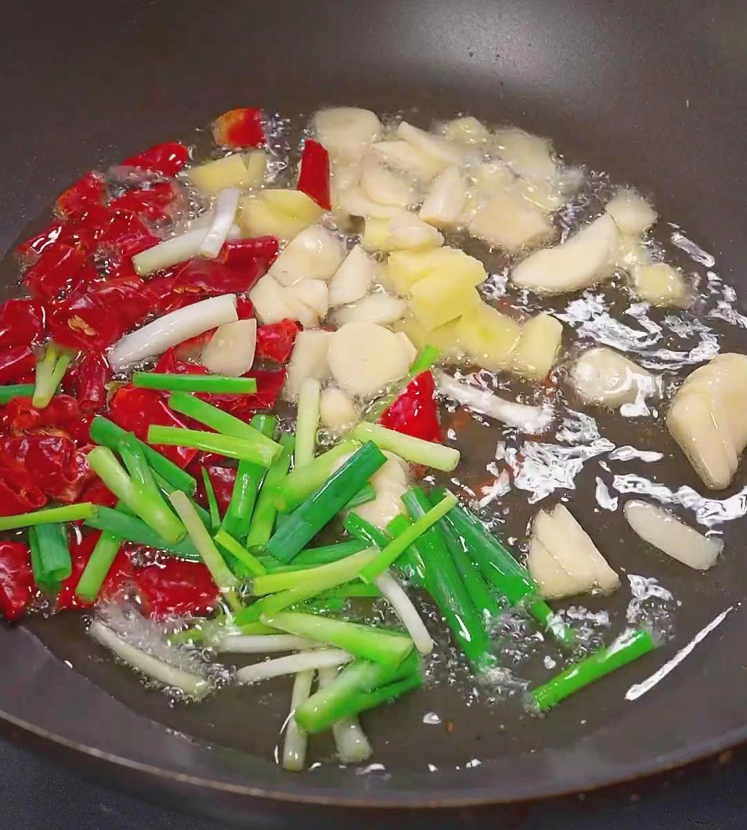 saute the chopped green onions, ginger, and dried peppers