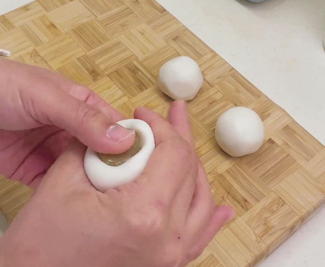 Add the filling, seal the top, and smoothen out the ball