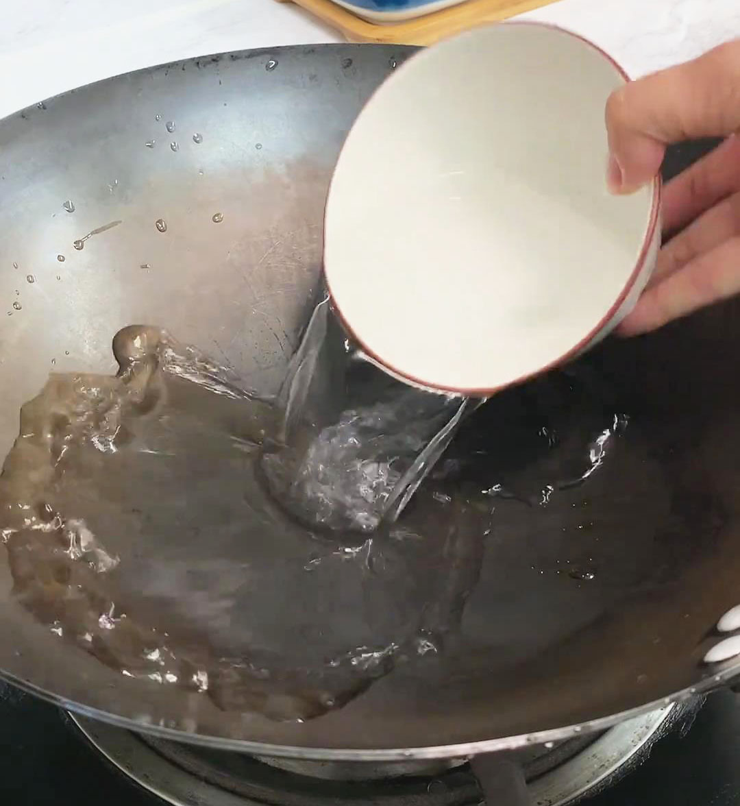 Pour a bowl of water into the iron pot for rendering