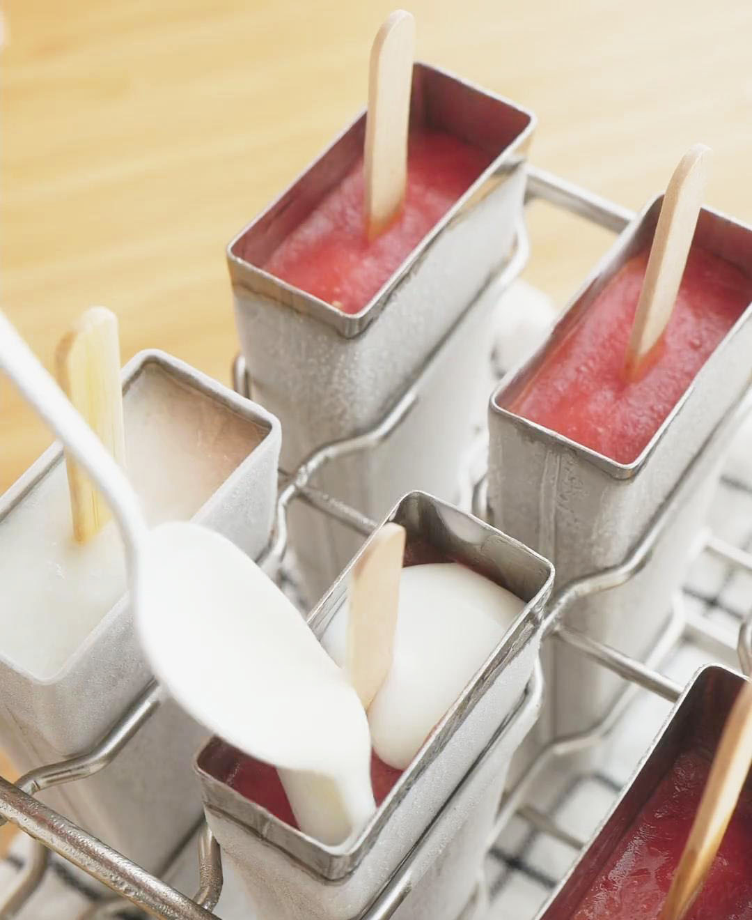 add a layer of yogurt on top of each popsicle