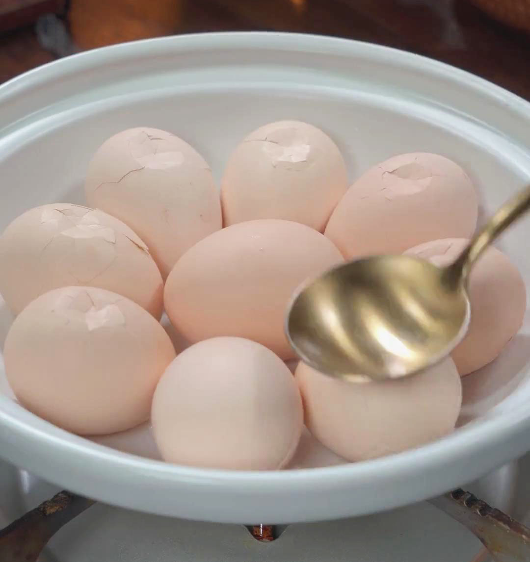 gently crack the eggshells using the back of the spoon