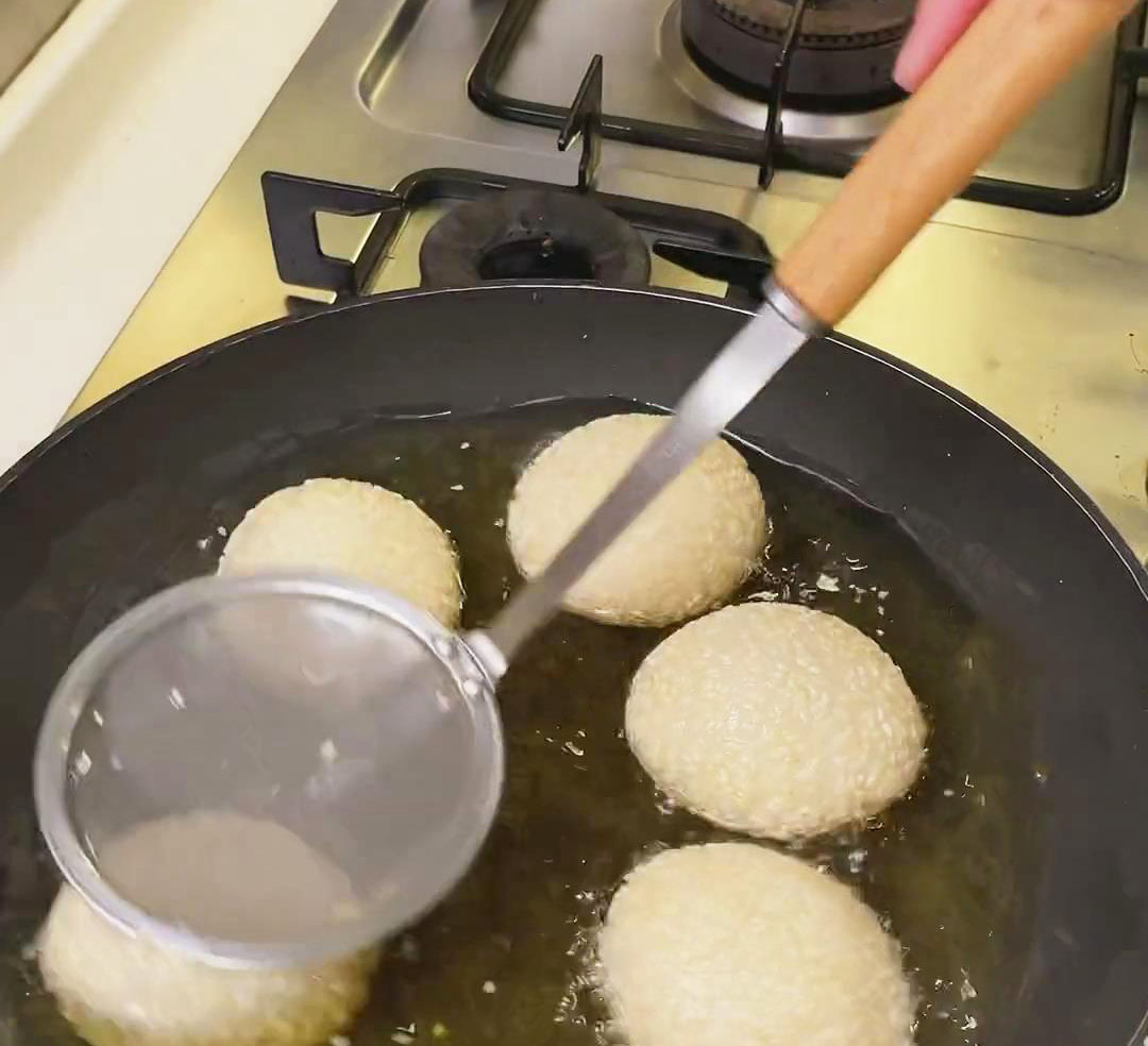 press sesame ball down to fully submerge in oil