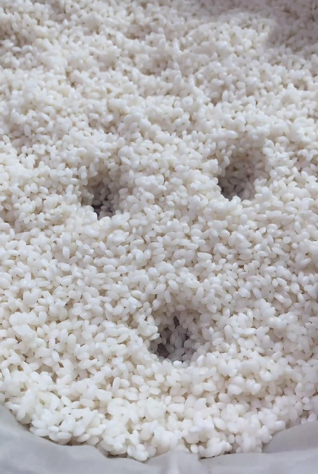 spread the rice evenly on a steamer tray lined with cloth and create holes in it