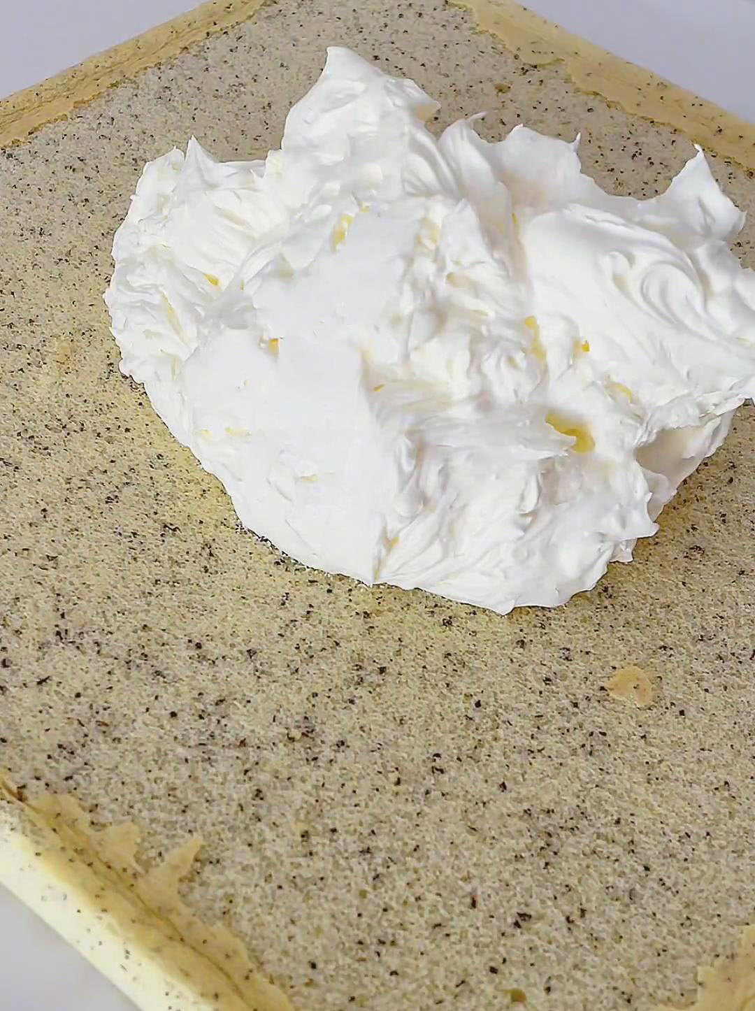 Spread the whipped cream evenly over the surface of the cake