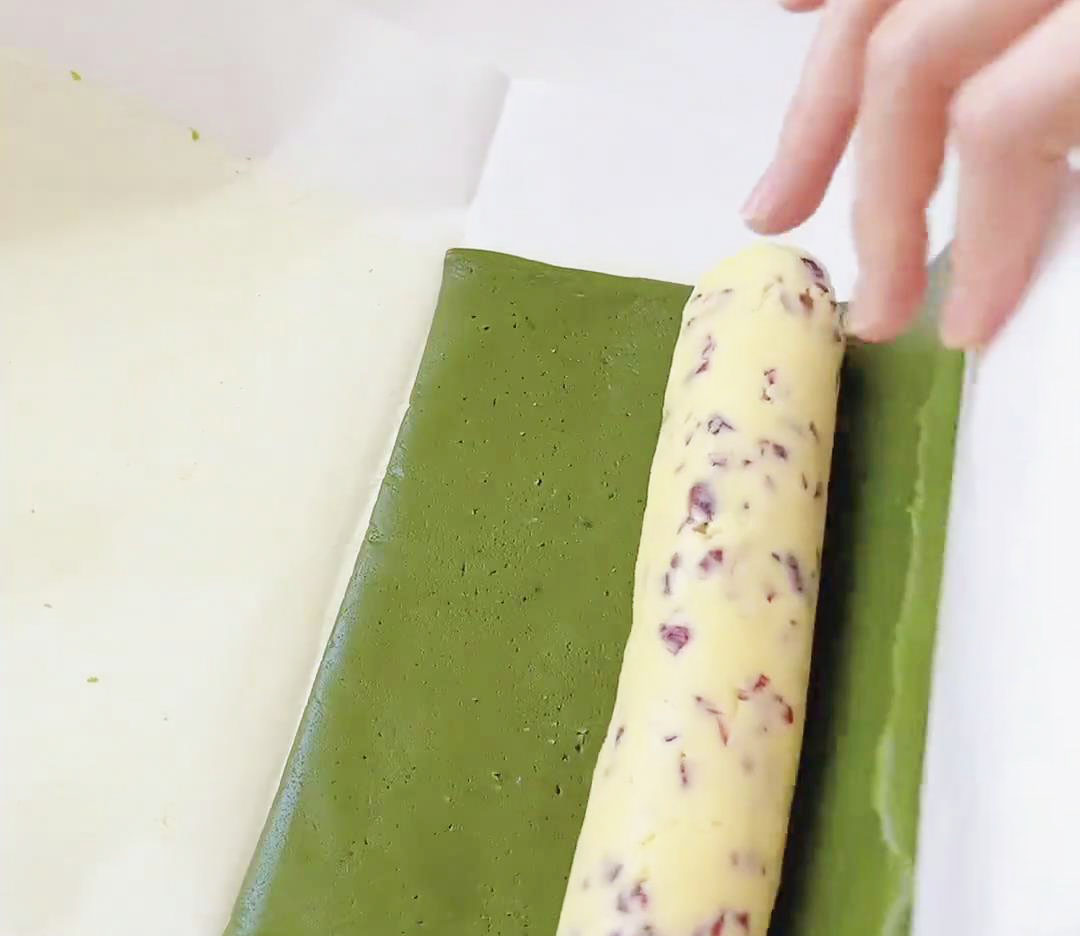 place the cranberry dough cylinder on top of the matcha dough sheet