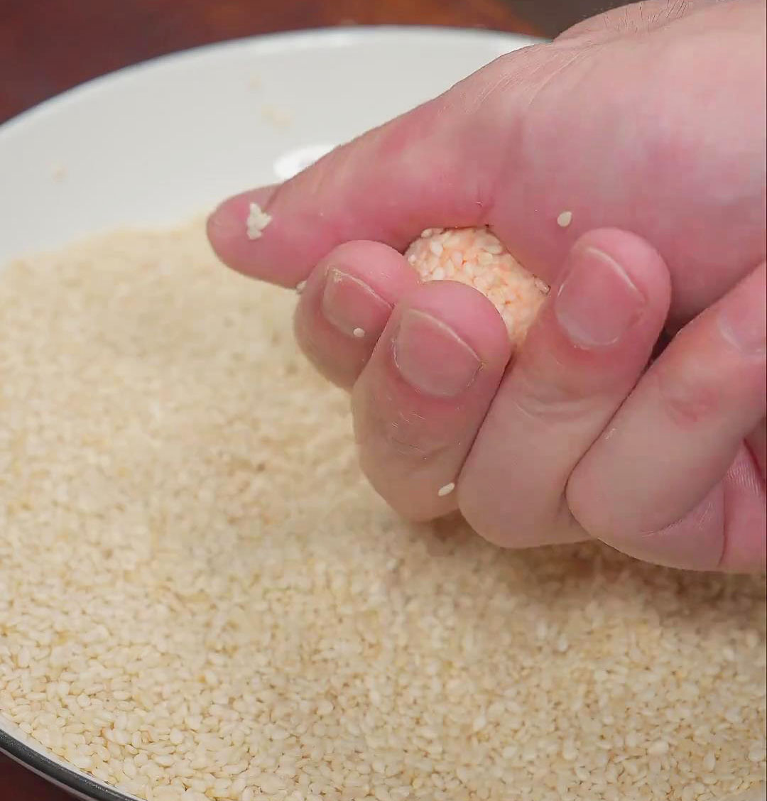 press the sesame seeds onto the balls to let them attach firmly