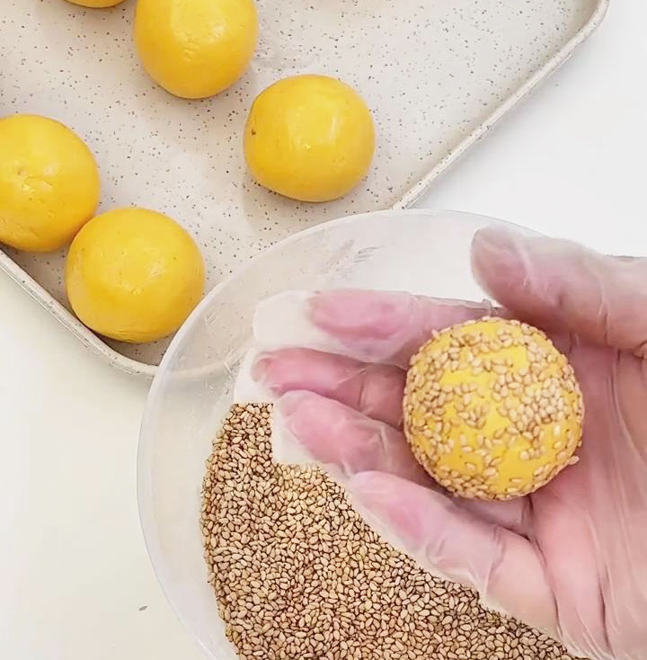 Roll the ball in sesame seeds until coated evenly