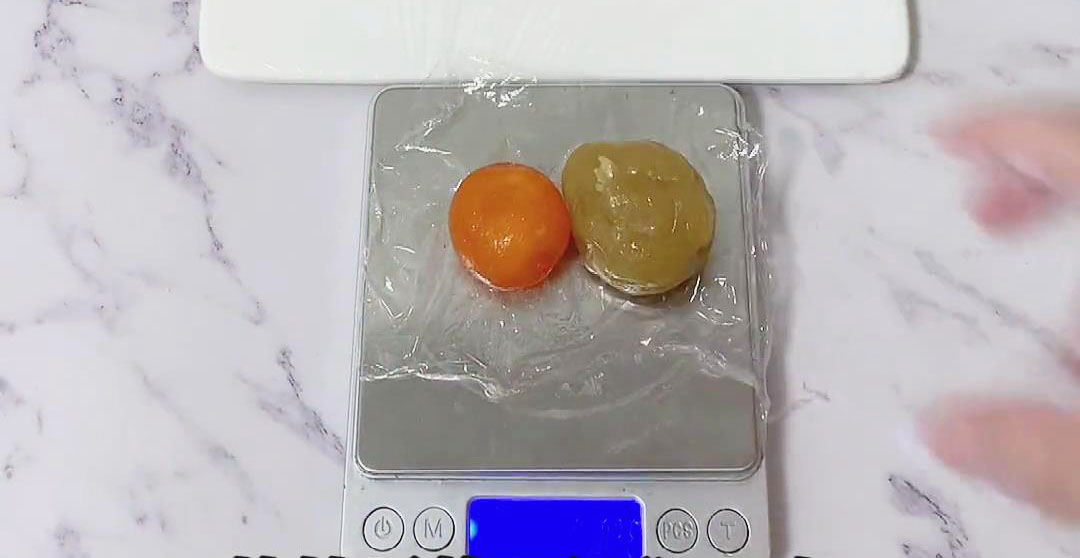 Weigh each piece of lotus paste ball and each egg yolk
