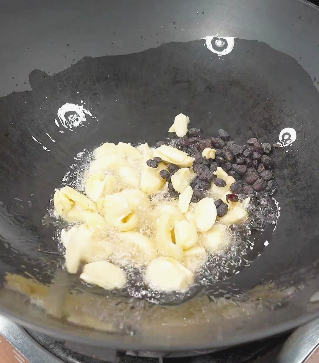 toss in garlic cloves and fermented black beans